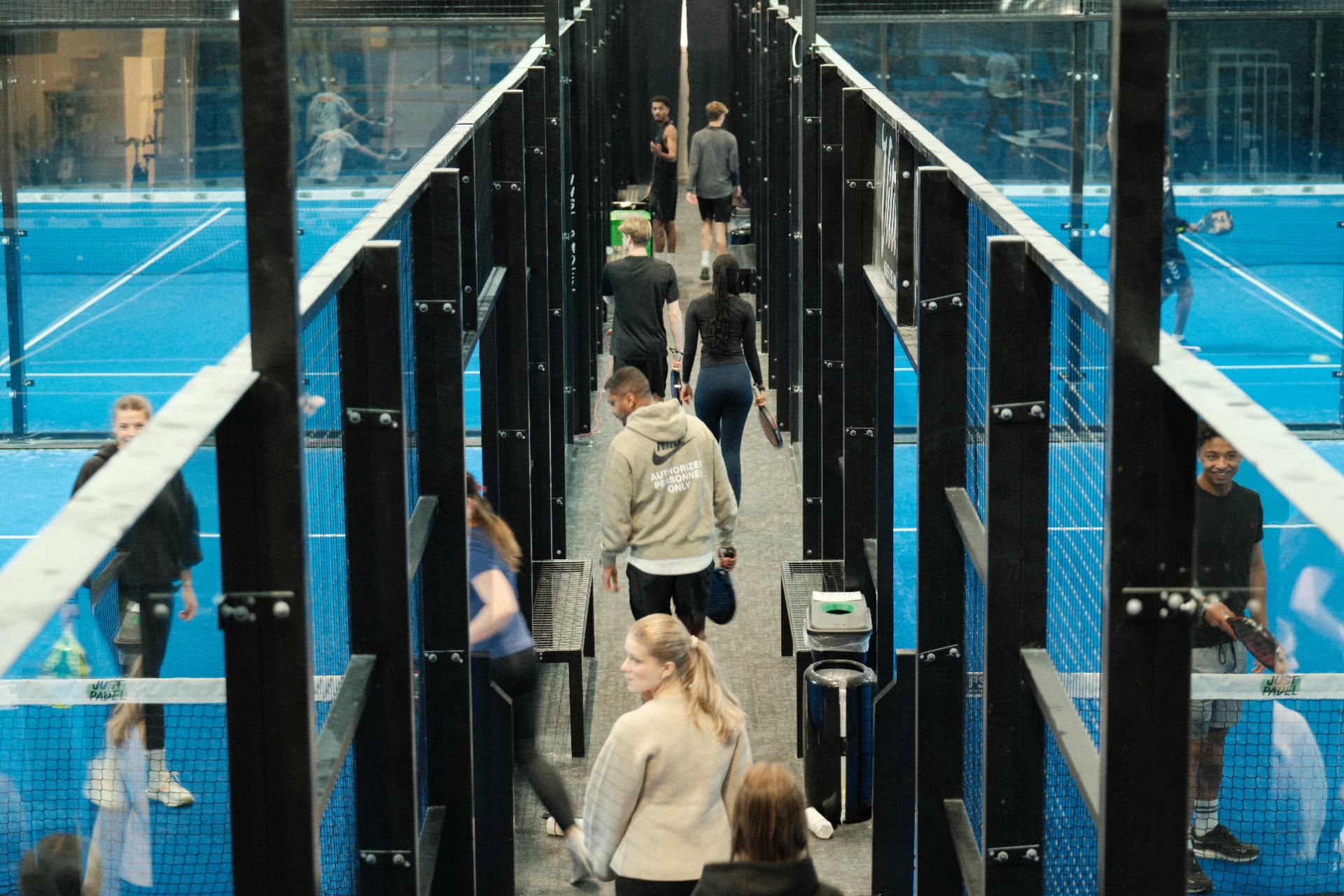 Deltakere går mellom padelbaner